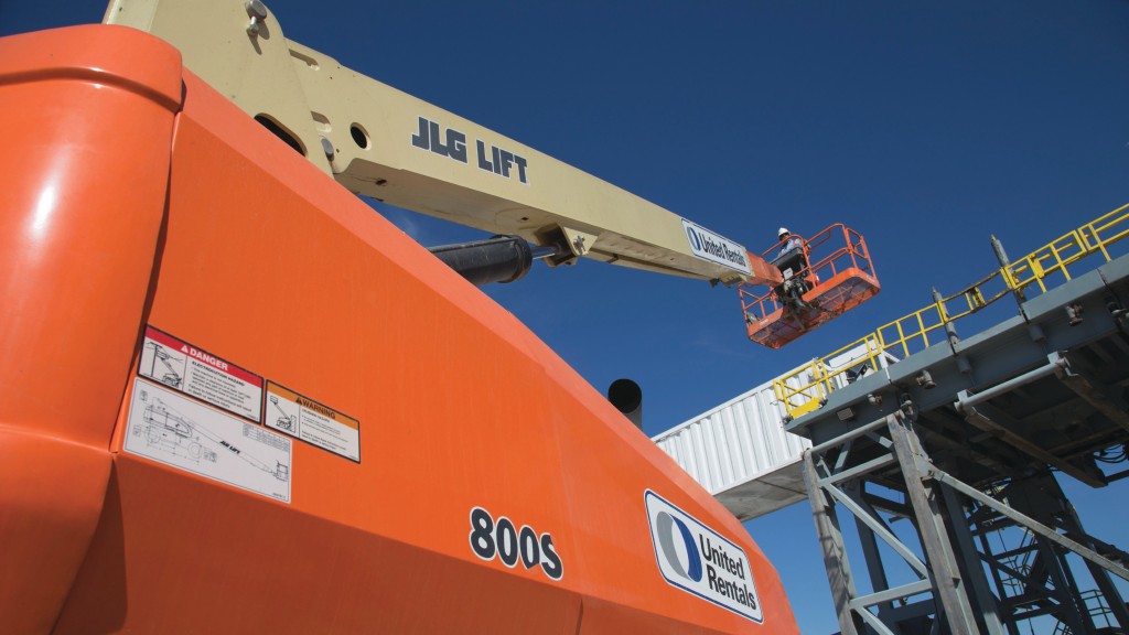 An operator uses a telescopic boom lift to reach a high structure