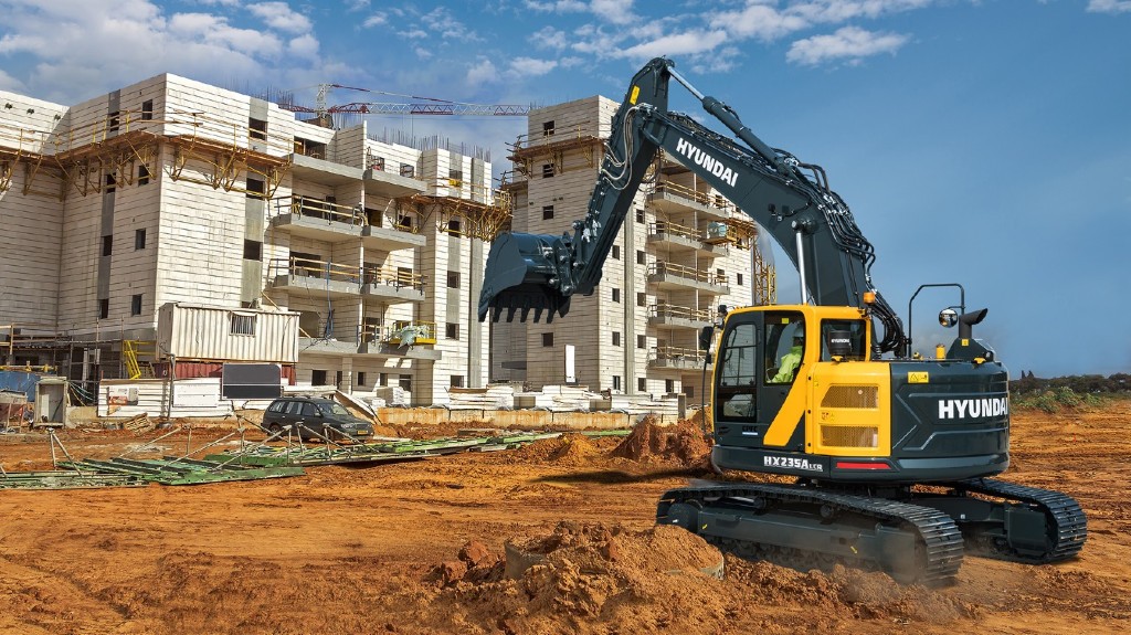 An excavator sits at an aged building
