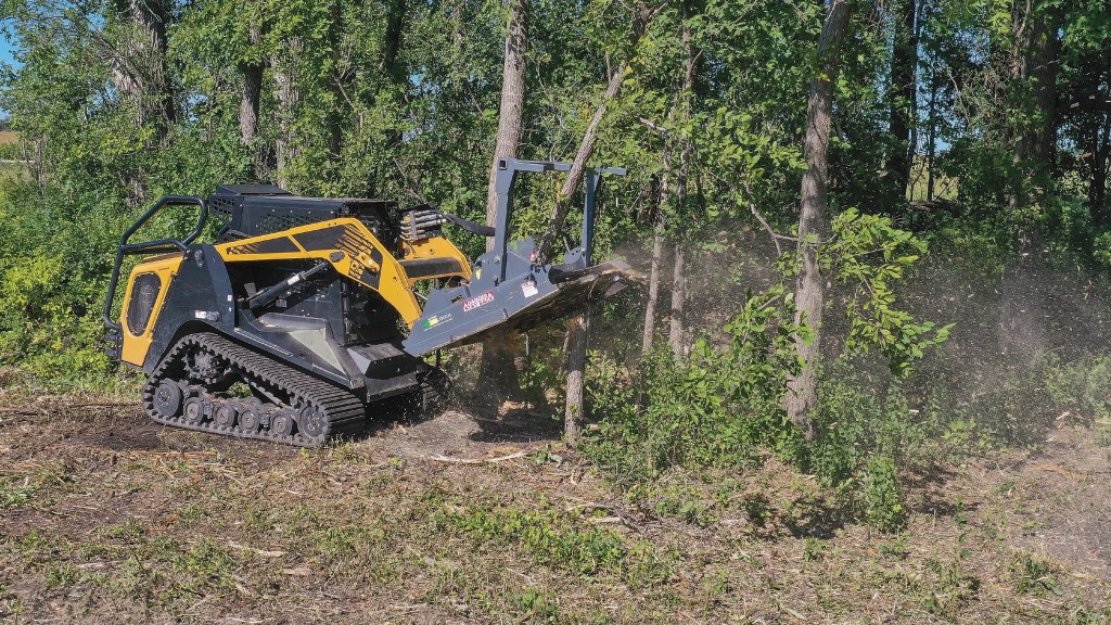 A mulcher shreds a tree stump on a job site