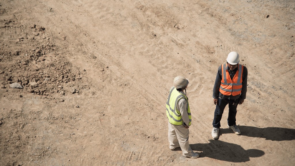 Two workers talk on a job site