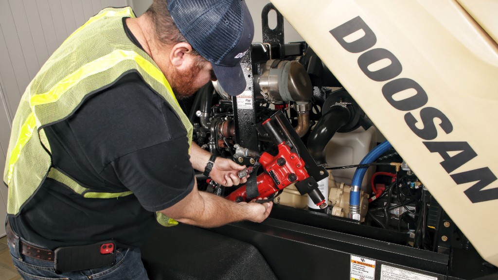 An operator uses a tool holder on an air compressor