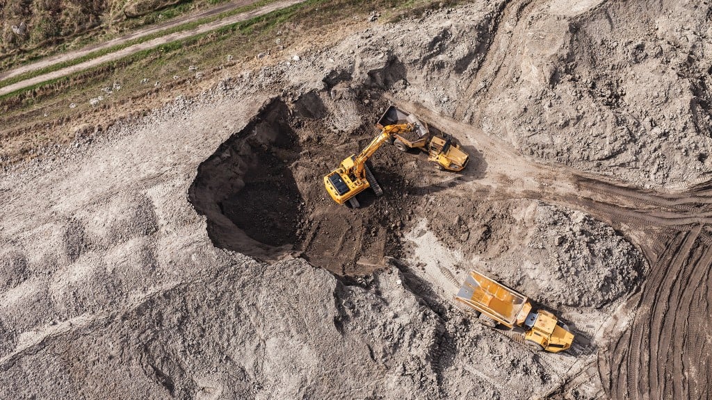 An excavator loads a truck on a job site