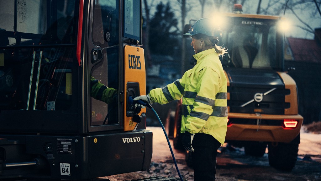 A worker plugs in a piece of electric construction equipment