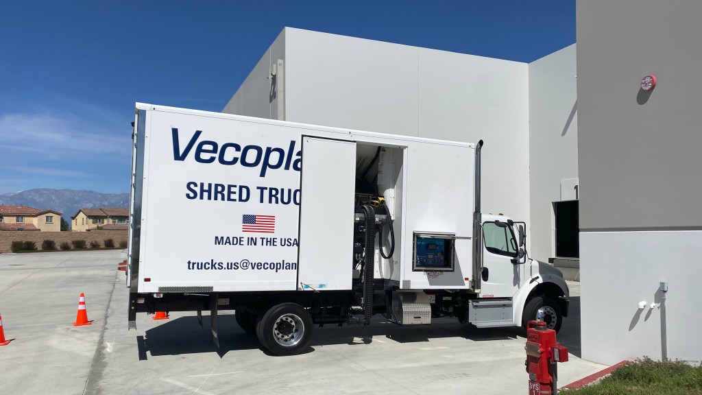 A paper shredding truck is parked at a facility