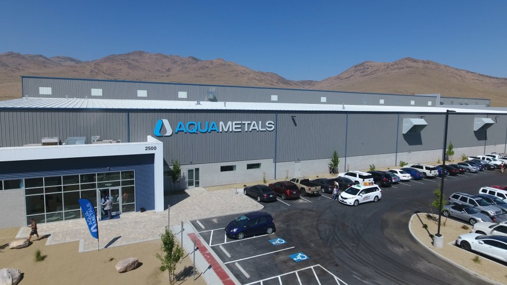 Cars are parked outside a large facility