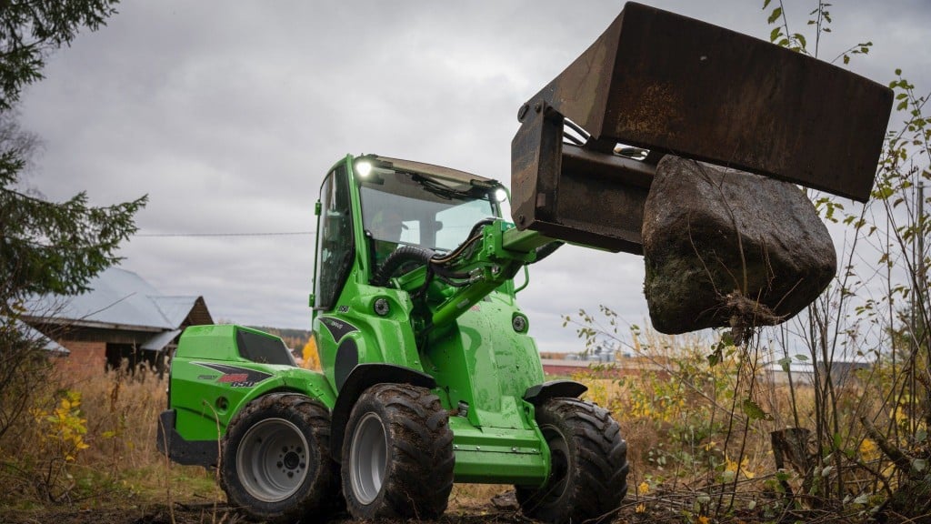 A loader drops a large rock from its bucket