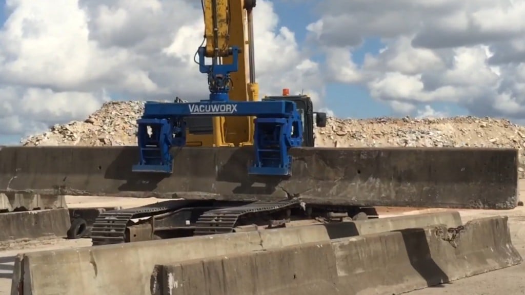 A piece of vacuum lifting equipment lifts a concrete barrier