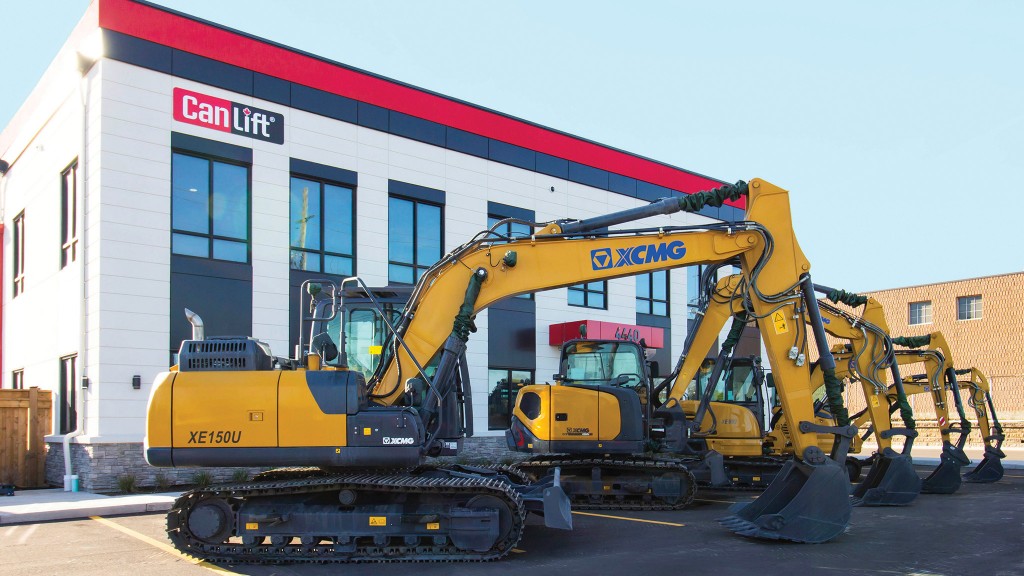 Several excavators are parked outside a dealership