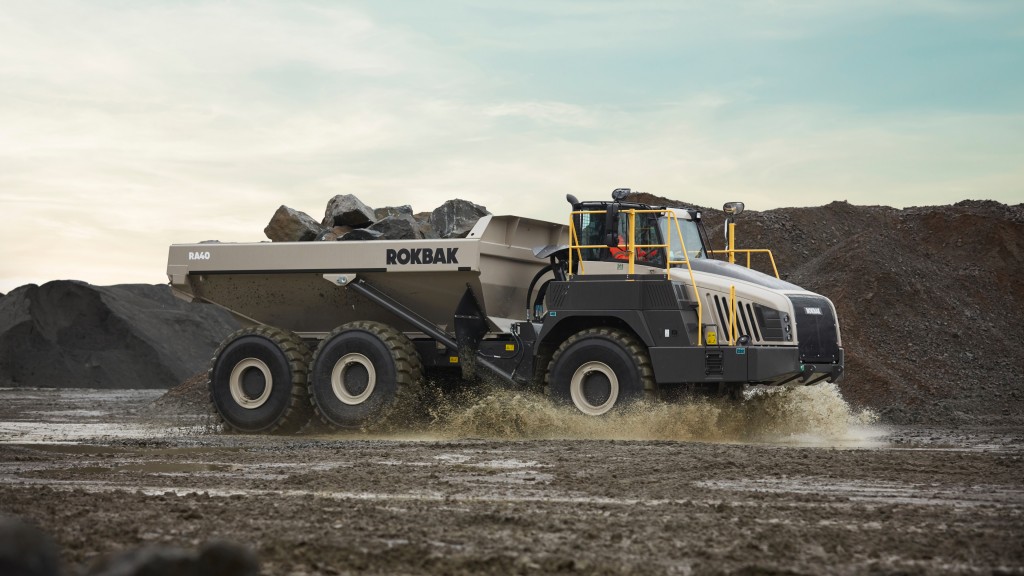 An articulated hauler drives down a muddy road