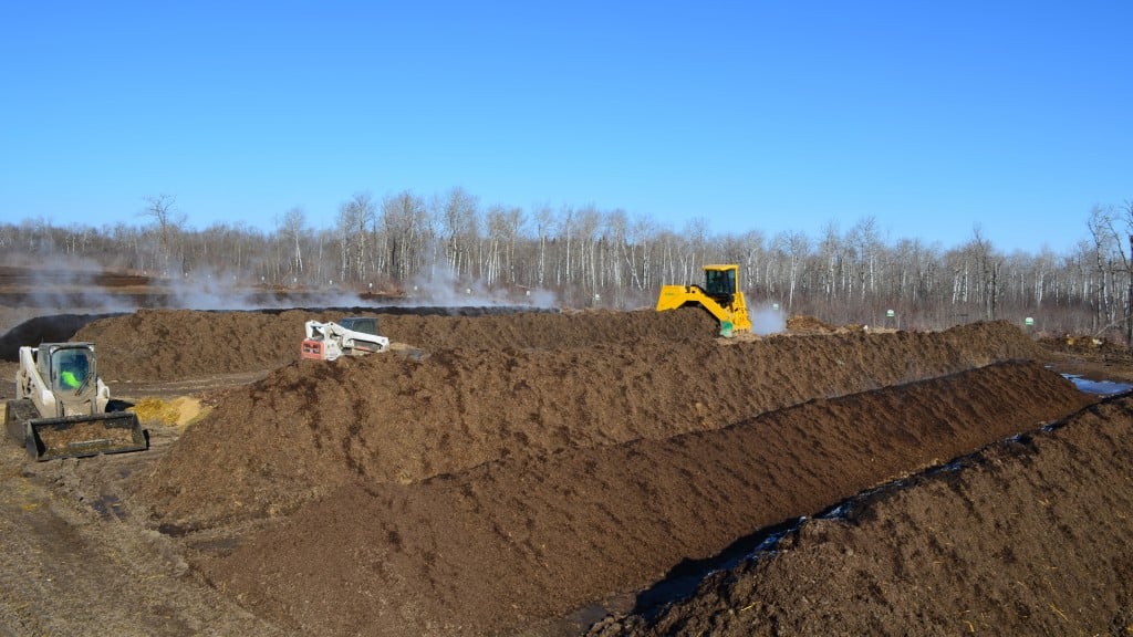Equipment drives around a composting windrow