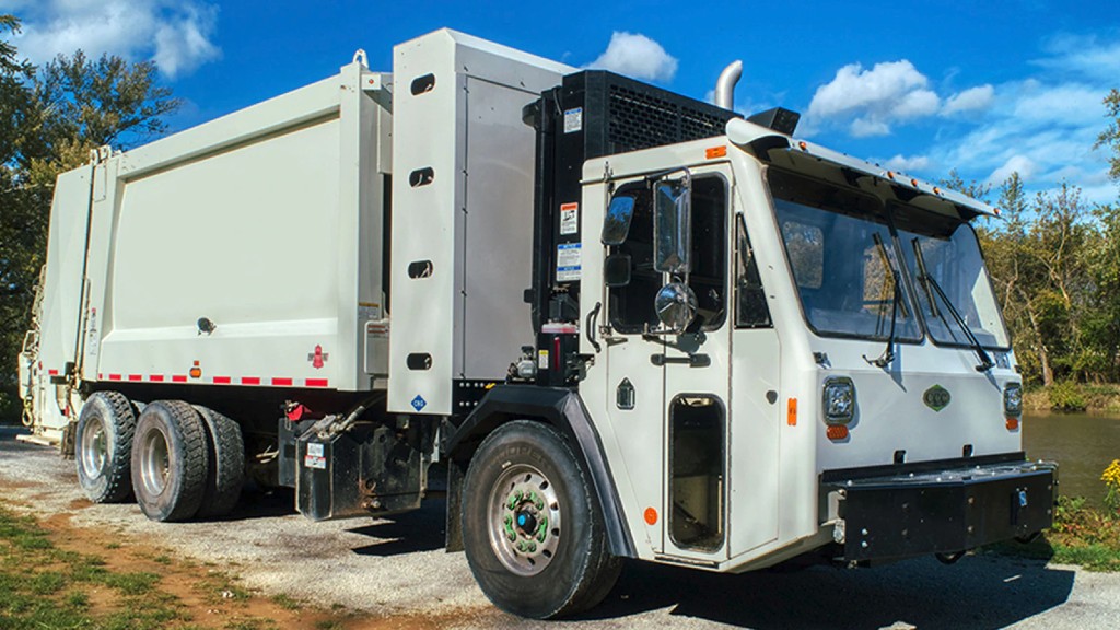 A cabover truck is parked on a gravel road