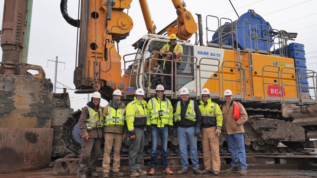 Several workers pose for a photo on a drill rig