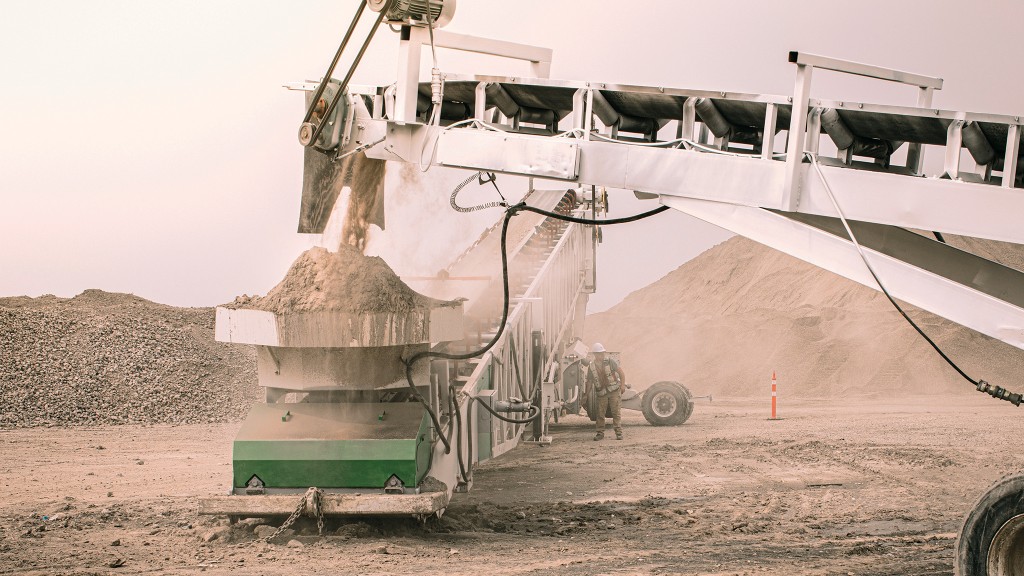 A conveyor moves crushed material on a job site