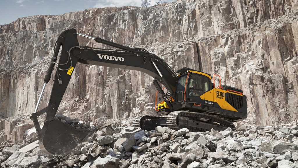 An excavator moves large rocks on a job site