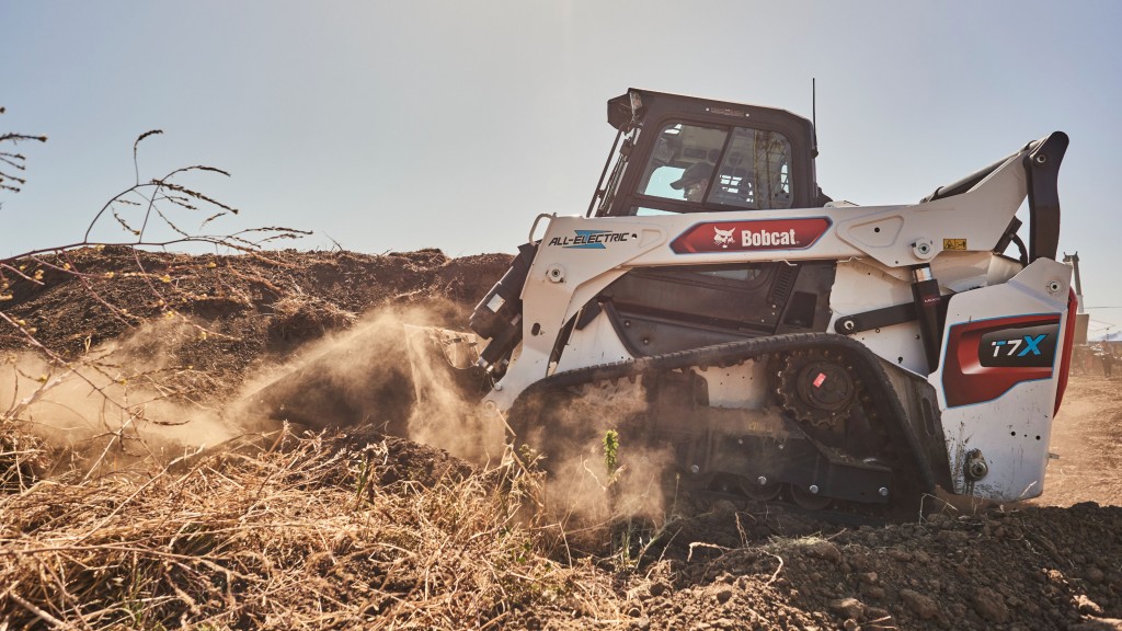 A compact track loader moves material at a demonstration site