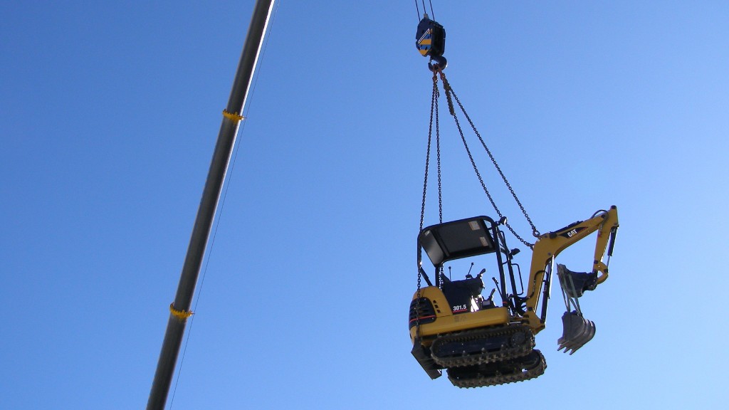 A mini excavator being lifted by a crane