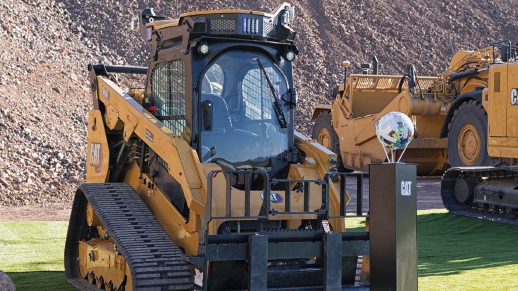 Caterpillar equipment is parked near a soccer ball in a stand
