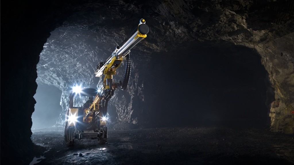 A drill rig travels down an underground mining tunnel