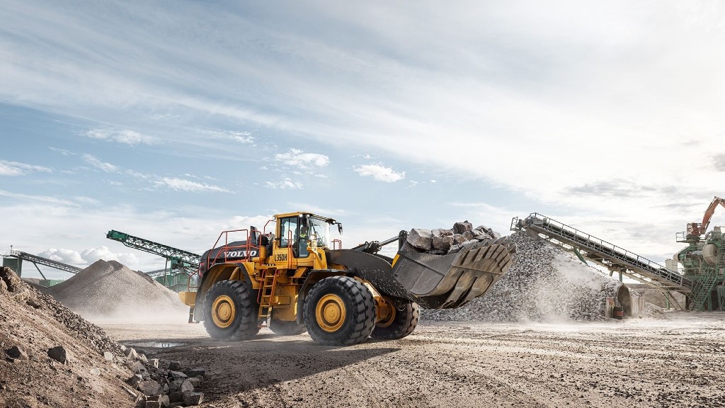 A wheel loader moves a bucket of rocks on a job site
