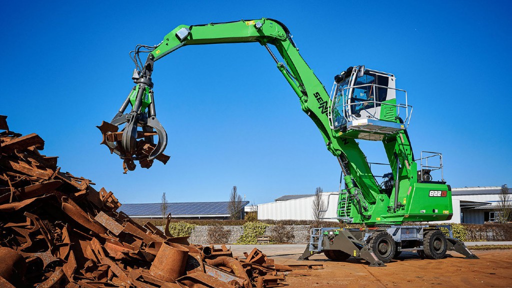 A material handler moves scrap metal on a job site