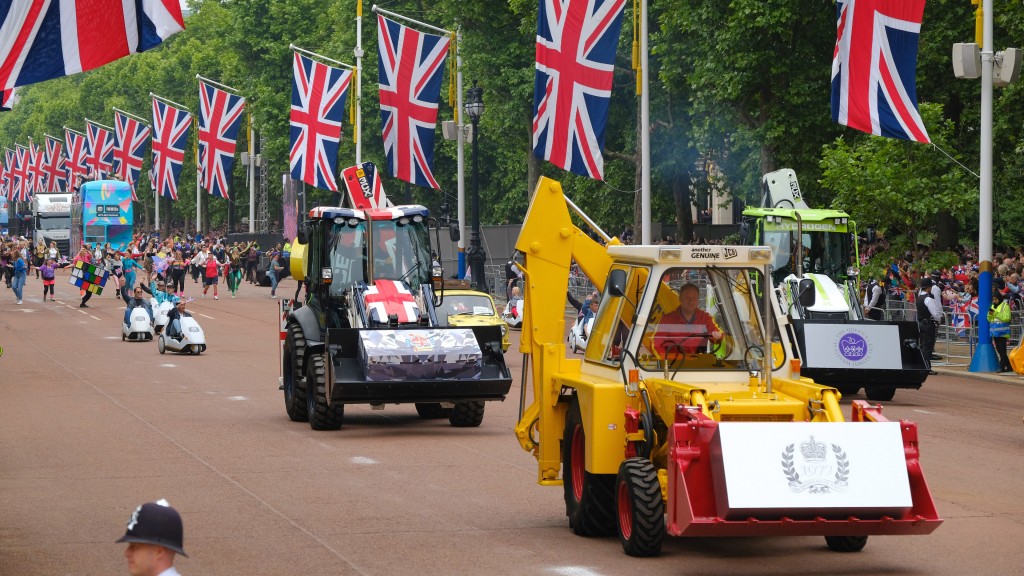 Backhoe loaders drive down a road