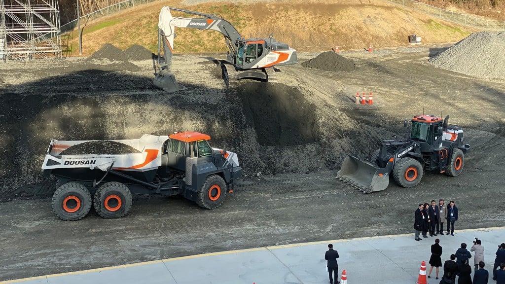 A wheel loader, hauler, and excavator operate on a job site