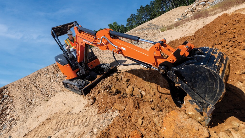 A compact excavator is being operated on a job site