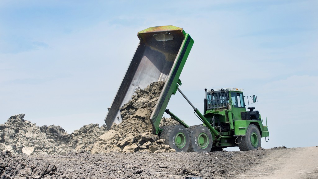 A trailer dumps rock on a job site