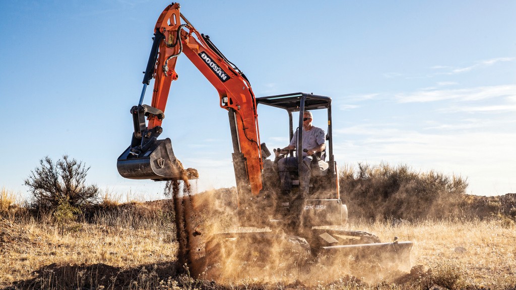 A mini excavator moves dirt on a job site