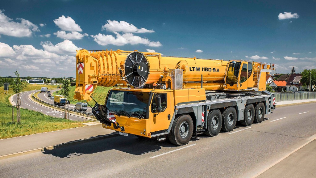 A mobile crane drives down a road