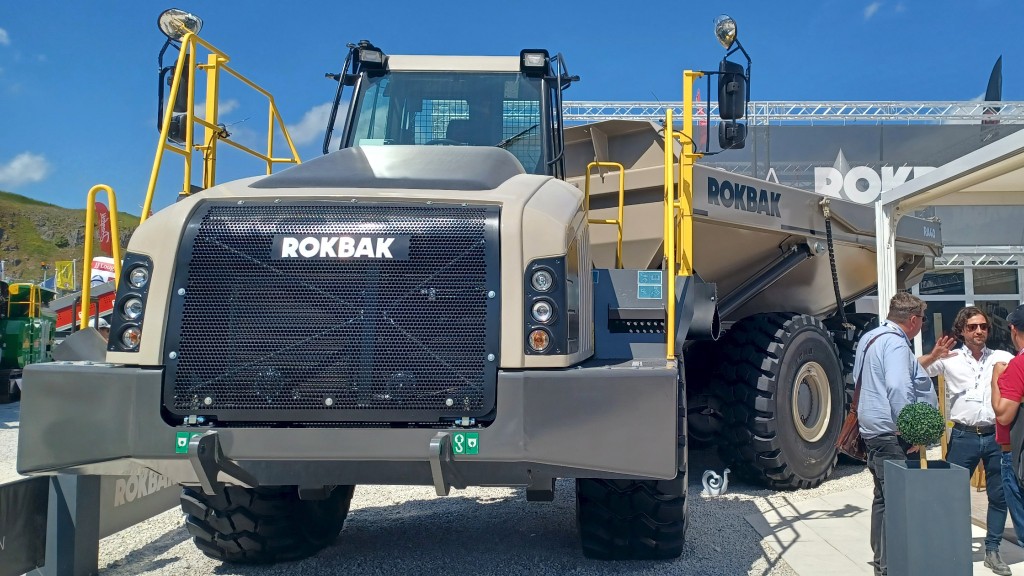 An articulated hauler is parked at a trade show