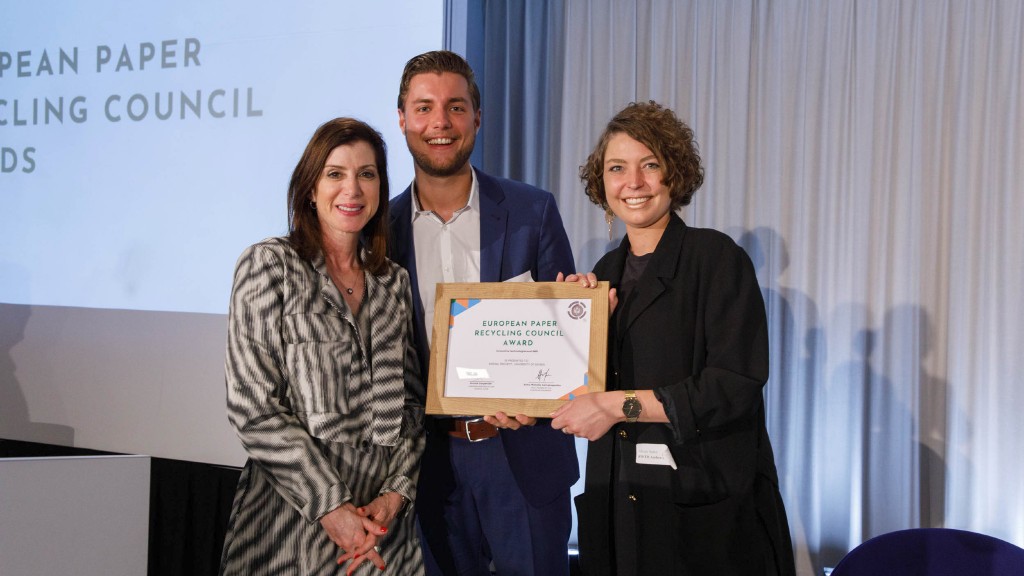 Two people accept a paper recycling award