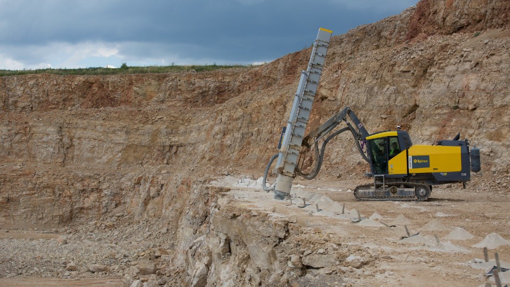 A drill rig operates near a small cliff