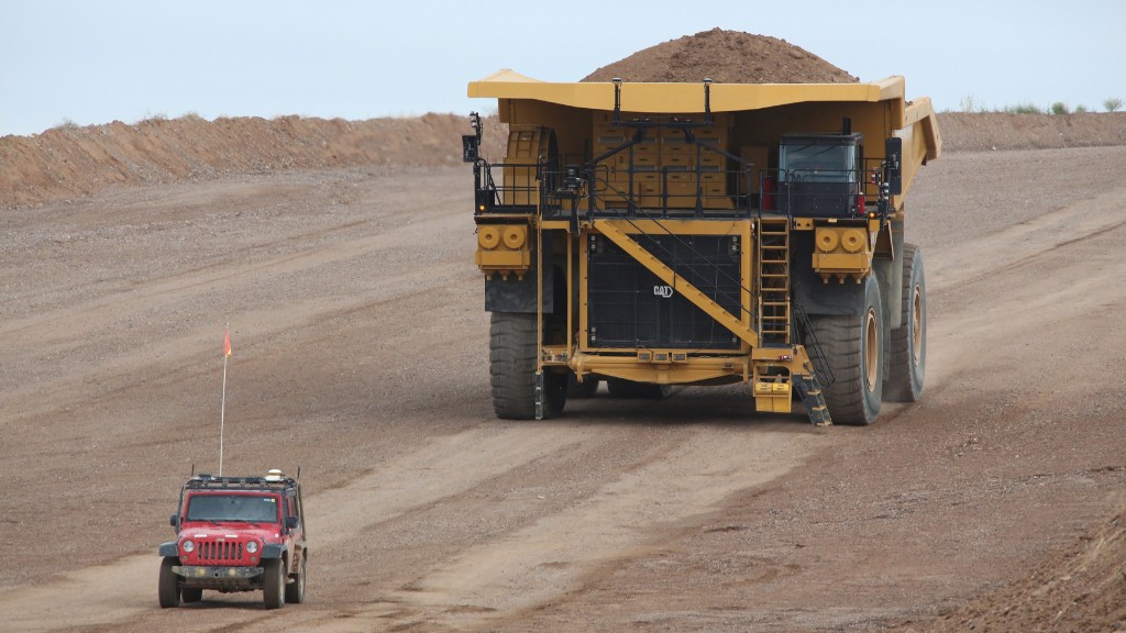 A mining truck carries a large load on a job site