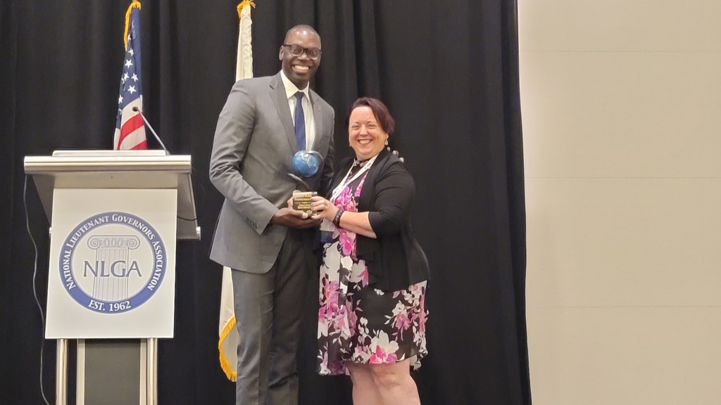 A Lieutenant Governor accepts an award on a stage