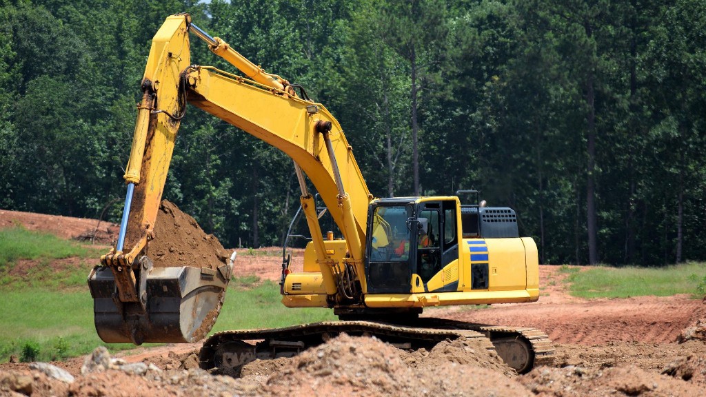 An excavator digs dirt on a job site