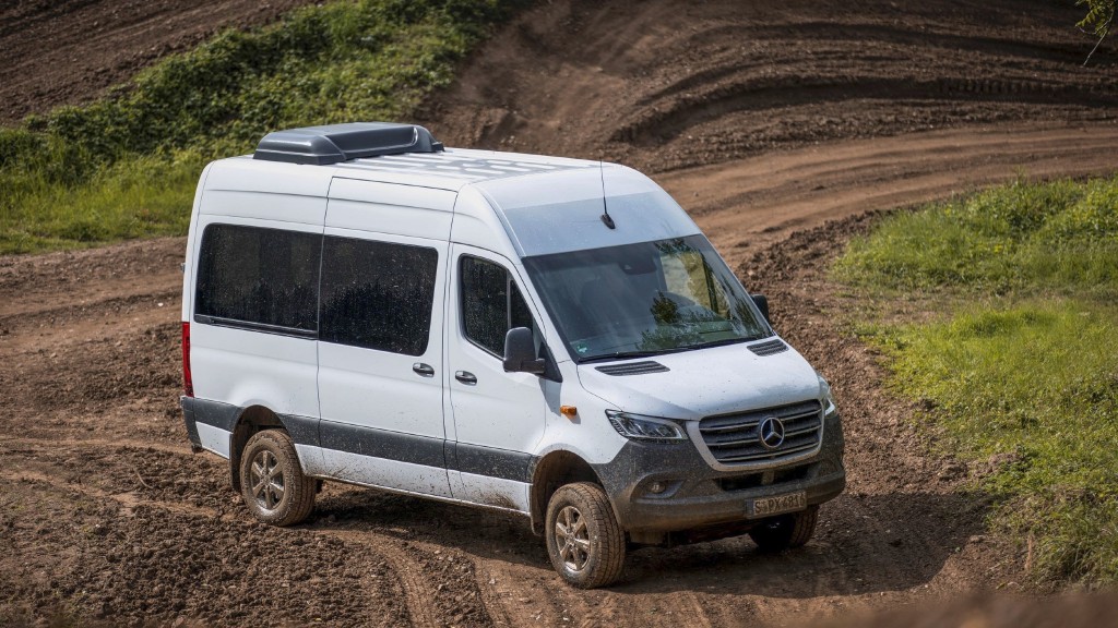 A van drives on a dirt road