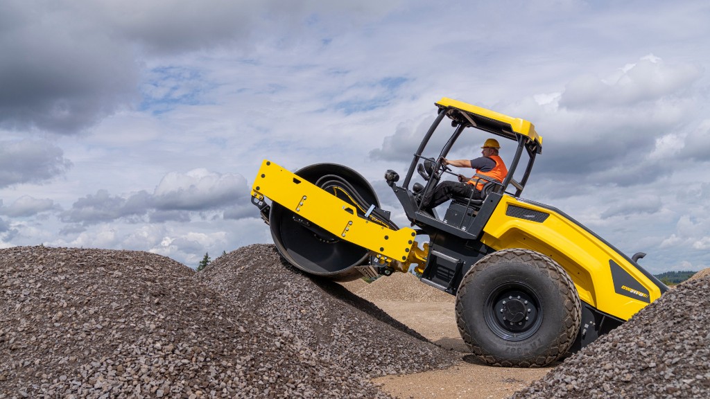 A single drum roller moves up a mound of loose material