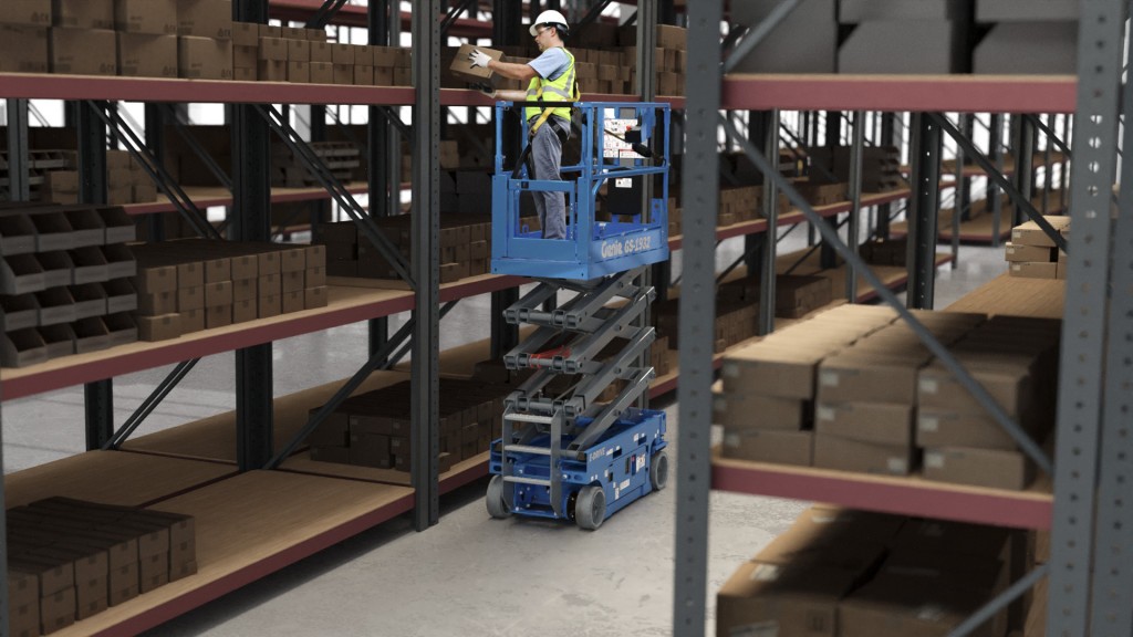 An operator grabs a package on a scaffold using a scissor lift