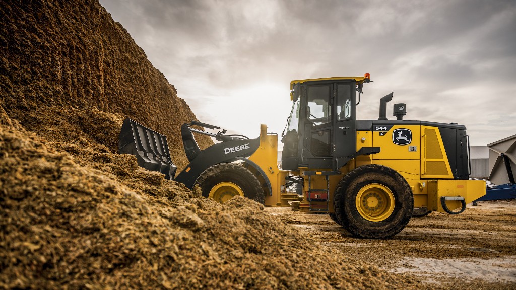 A wheel loader digs a bucket of dirt on the job site