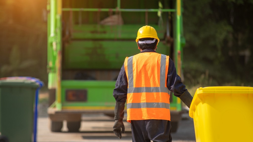 A collection worker walks to a truck