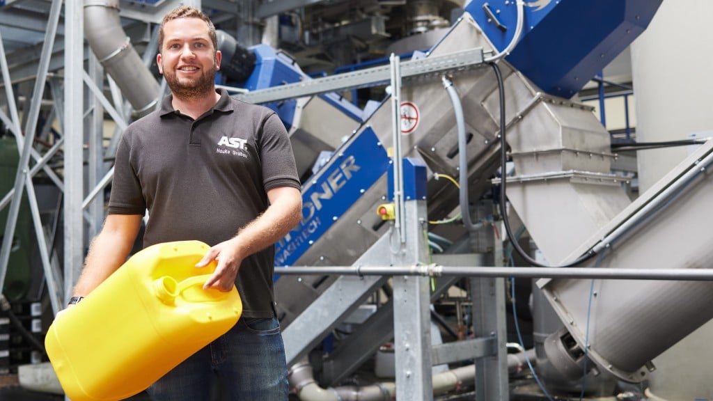 Somebody holds a plastic container in a recycling facility