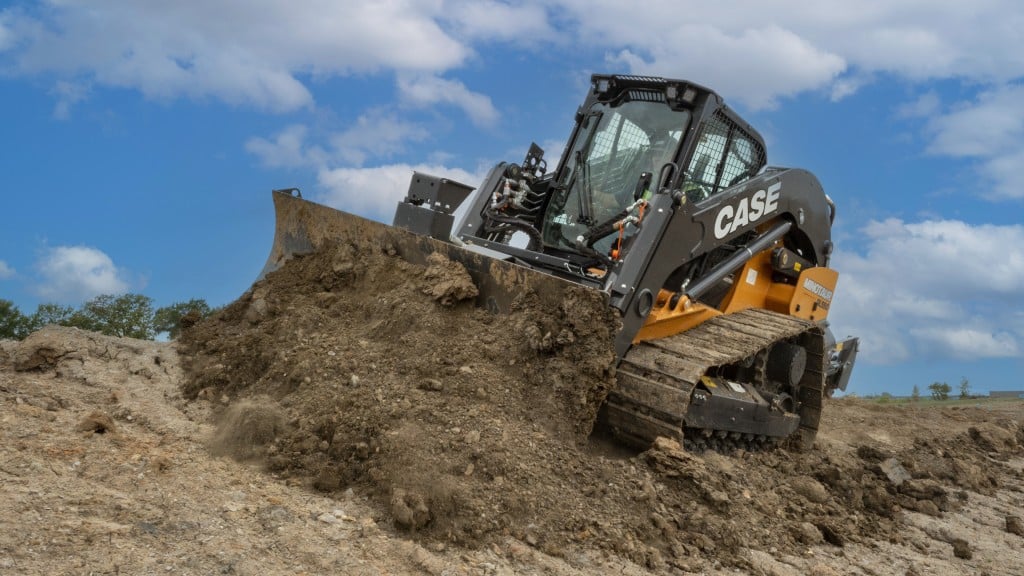 A compact dozer loader pushes dirt on a job site