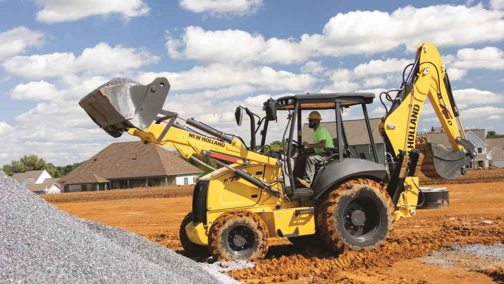 A backhoe loader moves rocks on a job site