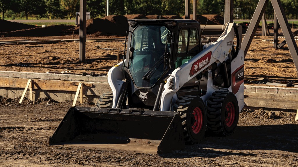 A skid steer loader with a bucket on a job site