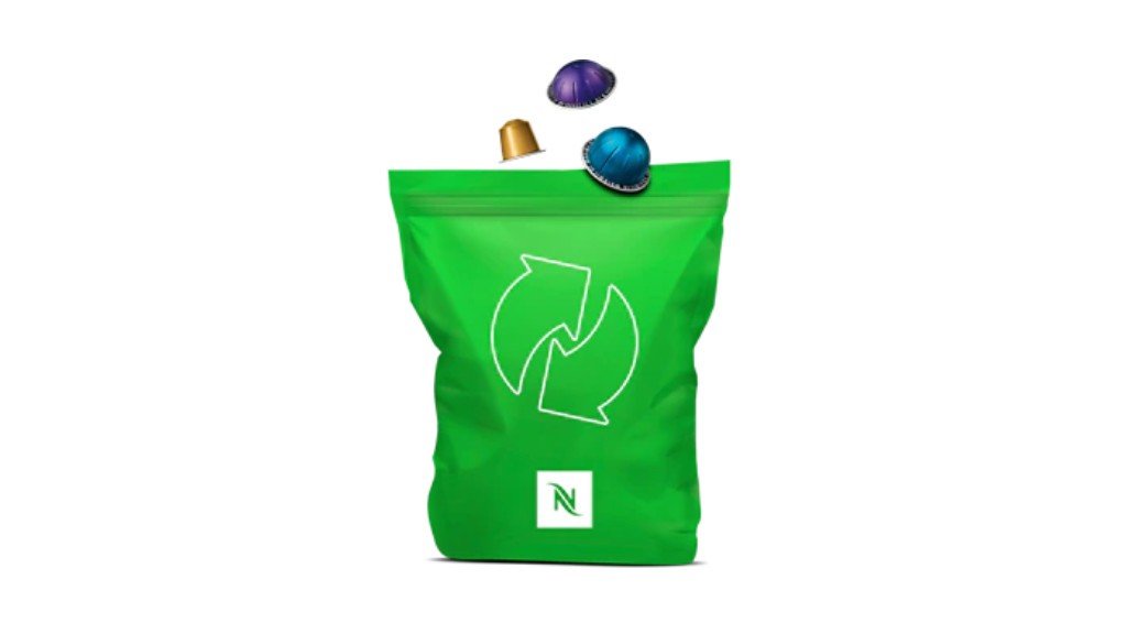 A green bag being filled with coffee pods