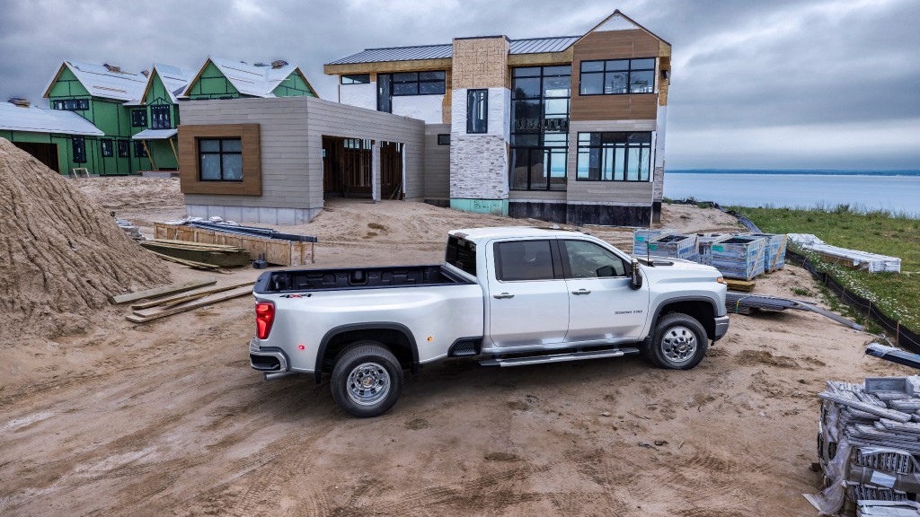 A pickup truck parked in front of a house under construction.