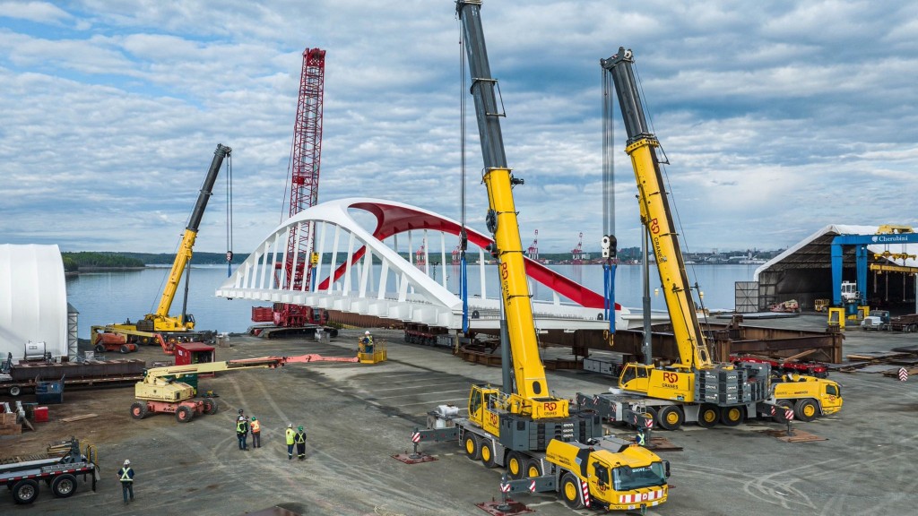 Four cranes lift a large bridge