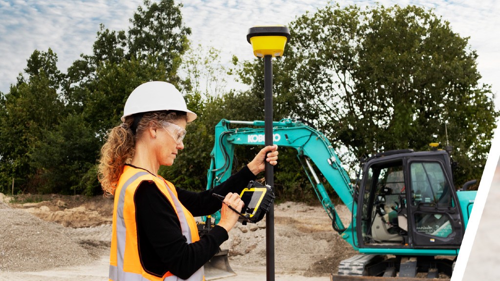 An operator uses a machine control antenna on a job site