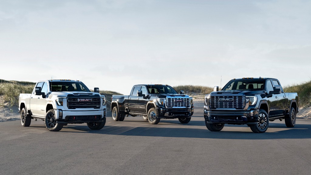 Three GMC pickups side by side on an asphalt pad.